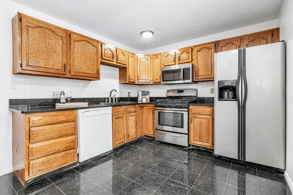 a kitchen with white cabinets and white appliances