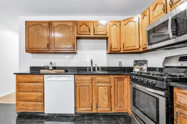 a kitchen with stainless steel appliances granite countertop a stove and a sink