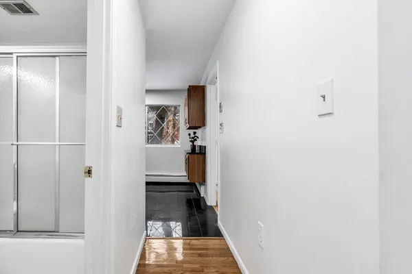 a view of a hallway with a white walls and a bathroom