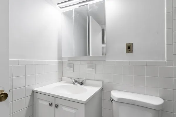 a bathroom with a toilet sink and mirror