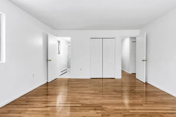 a view of an empty room with wooden floor
