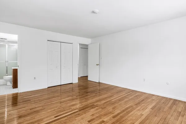 a view of an empty room with wooden floor