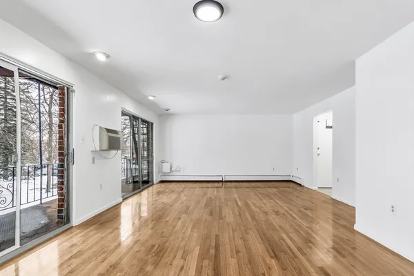 a view of a room with wooden floor and window