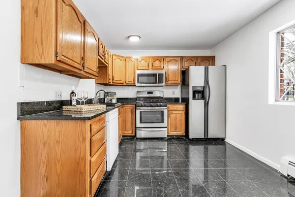 a kitchen with stainless steel appliances granite countertop a stove a sink and a refrigerator