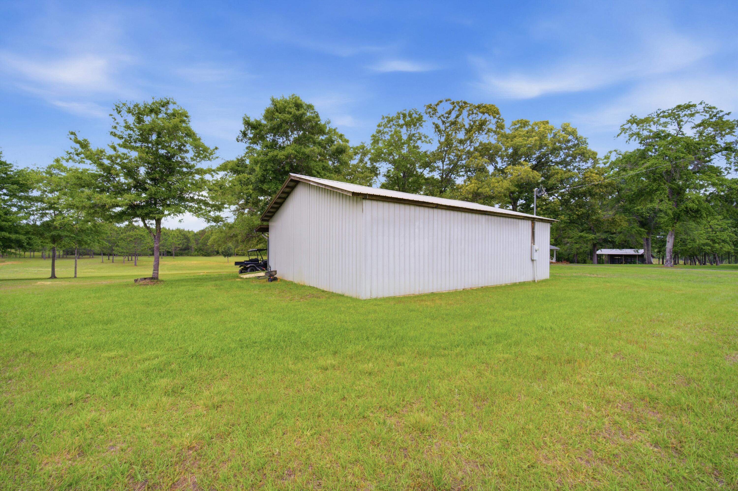 261 Wilkerson Road DeFuniak Springs, FL 32433 - Photo 76 of 76 a backyard of a house with lots of green space and garden
