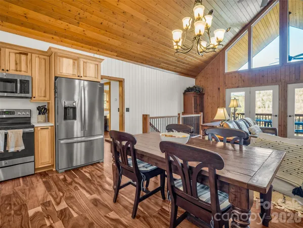 a view of a dining room with furniture a chandelier and wooden floor