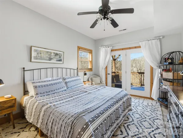 a bedroom with a large bed and a chandelier