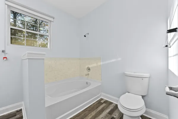 a white toilet sitting next to a bath tub