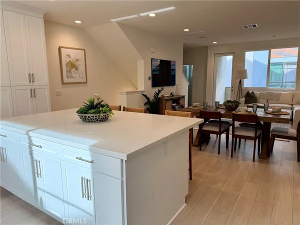 a kitchen with a dining table chairs and white cabinets