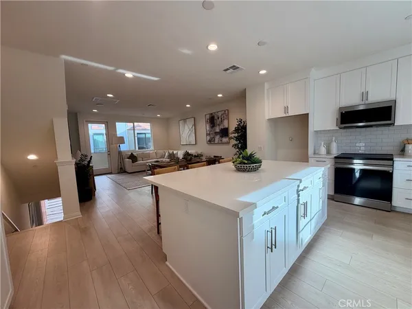 a large kitchen with stainless steel appliances a large counter top a stove and a sink