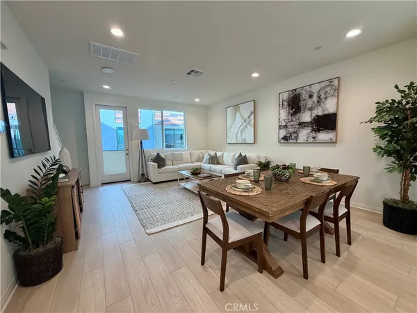 a view of a a dining room with furniture window and wooden floor