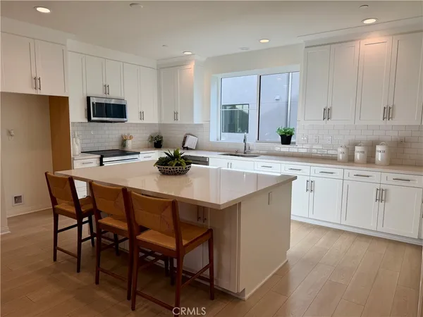 a kitchen with a sink stools a counter space and cabinets