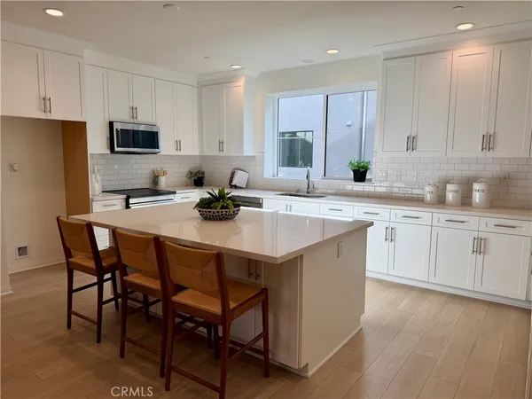 a kitchen with a sink stools a counter space and cabinets