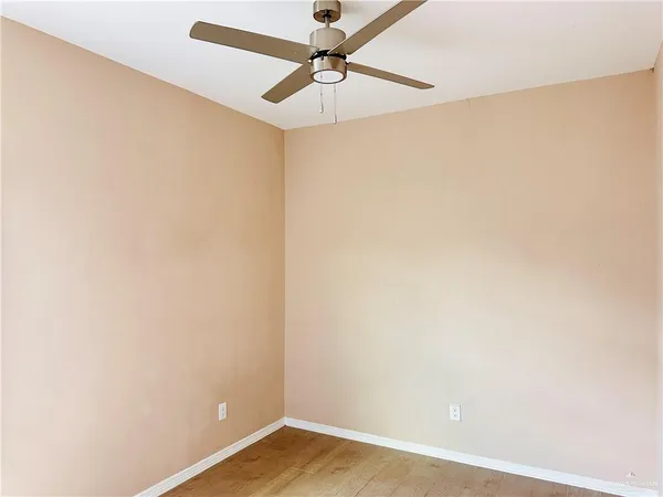 an empty room with a window and a ceiling fan