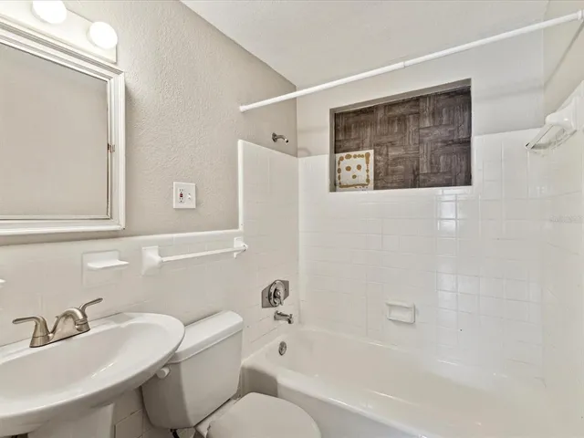 a bathroom with a toilet a sink and bathtub