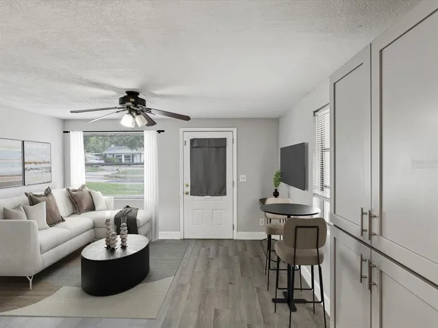 a living room with furniture a flat screen tv and a window