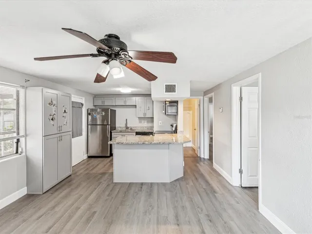 a kitchen with stainless steel appliances a refrigerator and wooden floor