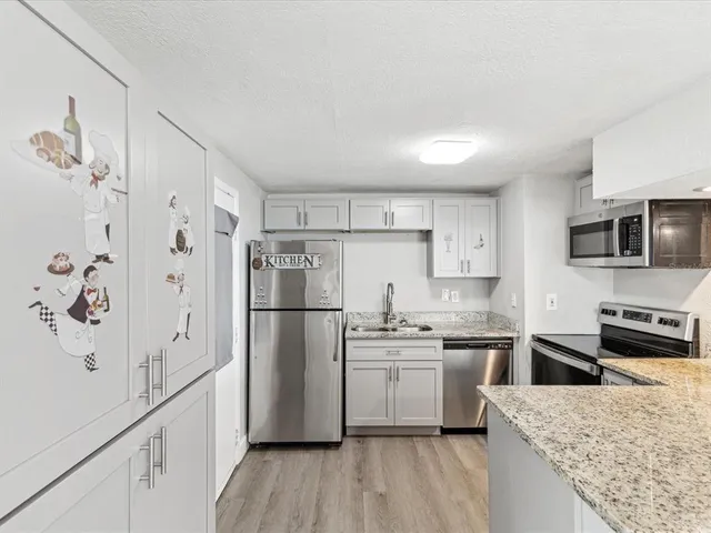 a kitchen with white cabinets and stainless steel appliances
