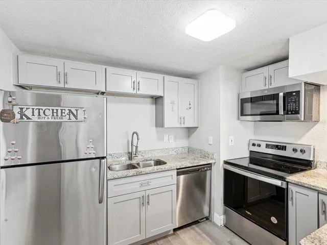 a kitchen with appliances a sink and cabinets