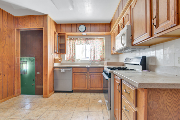 1067 West 97th Street Chicago, IL 60643 - Photo 7 of 15 a kitchen with stainless steel appliances granite countertop a stove a sink and a refrigerator