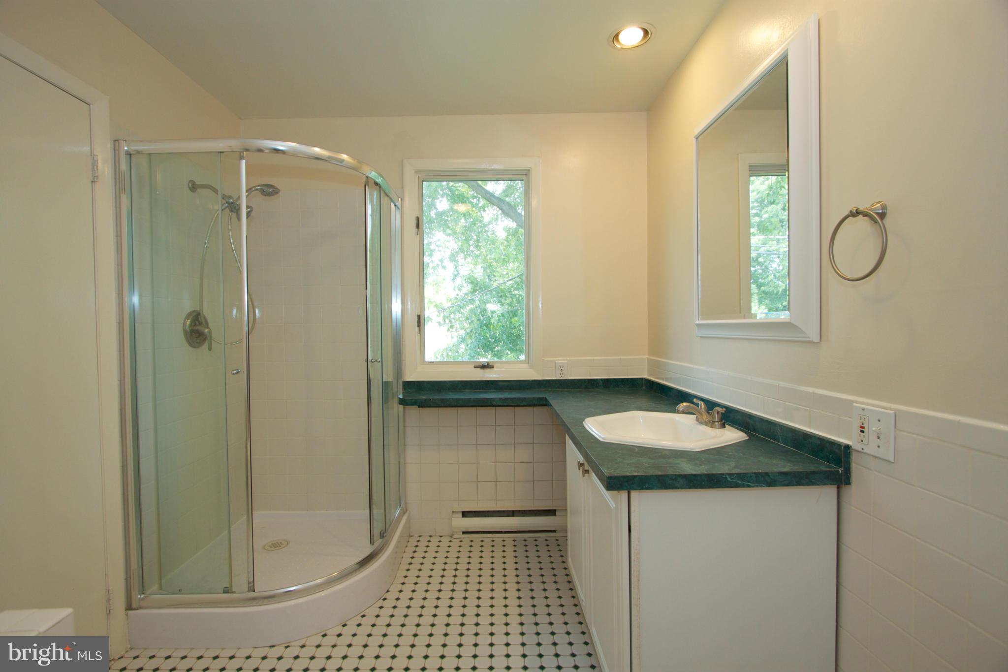 8438 Coco Road Baltimore, MD 21237 - Photo 17 of 29 a bathroom with a granite countertop sink a toilet and shower
