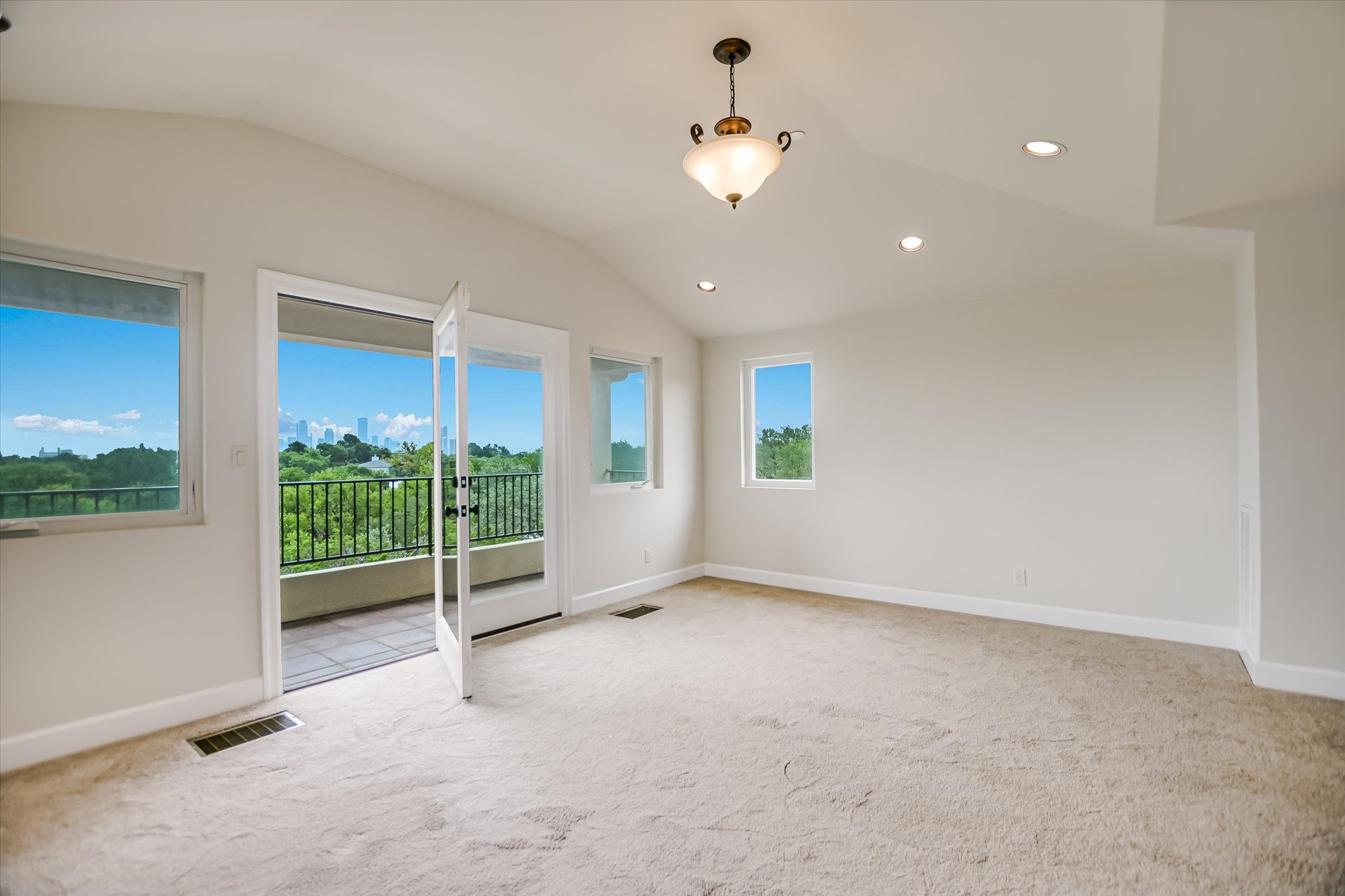 11 Inwood Circle Austin, TX 78746 - Photo 31 of 38 Office, Exercise, or Flex room with a vaulted ceiling and a private balcony overlooking a vibrant cityscape.