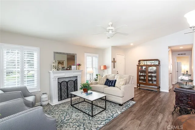 a living room with furniture a fireplace and a large window