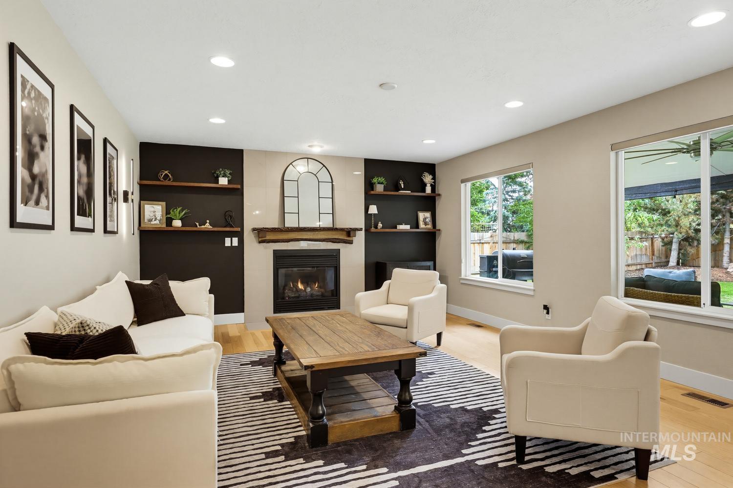 369 South Winthrop Way Boise, ID 83709 - Photo 10 of 50 Living area featuring a central fireplace with a rustic wood mantel, flanked by built-in shelving and recessed lighting