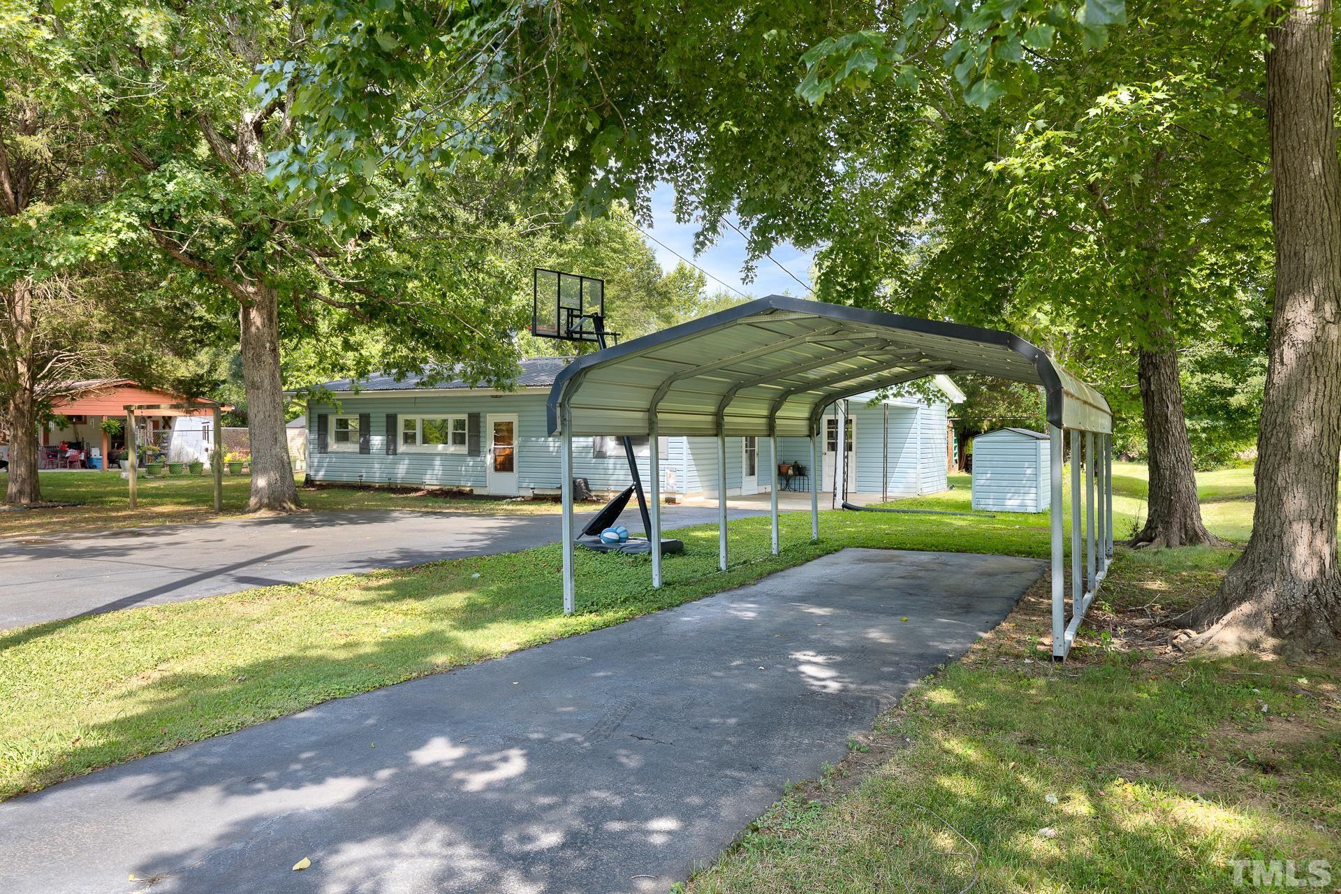724 Bill Poole Road Rougemont, NC 27572 - Photo 2 of 17 a view of a patio with a table and chairs under an umbrella