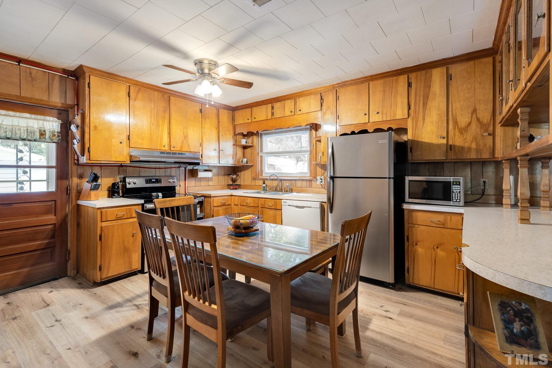 724 Bill Poole Road Rougemont, NC 27572 - Photo 6 of 17 a kitchen with refrigerator a stove a dining table and chairs