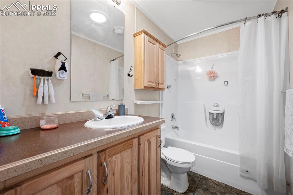 8395 Commanche Road Colorado Springs, CO 80926 - Photo 14 of 29 a bathroom with a sink a toilet and shower curtain