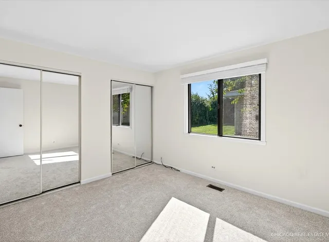 an empty room with windows and closet