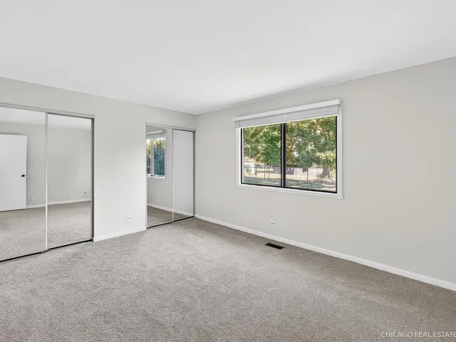 an empty room with windows and closet