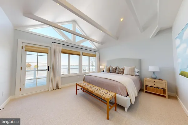 a spacious bedroom with a bed and a large window