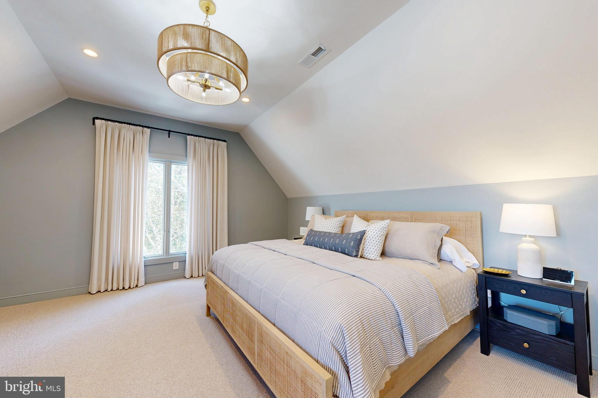 601 Cove Road St. Michaels, MD 21663 - Photo 19 of 39 a spacious bedroom with a bed and a chandelier
