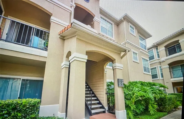 a view of a brick building with a bench and table in front of a house