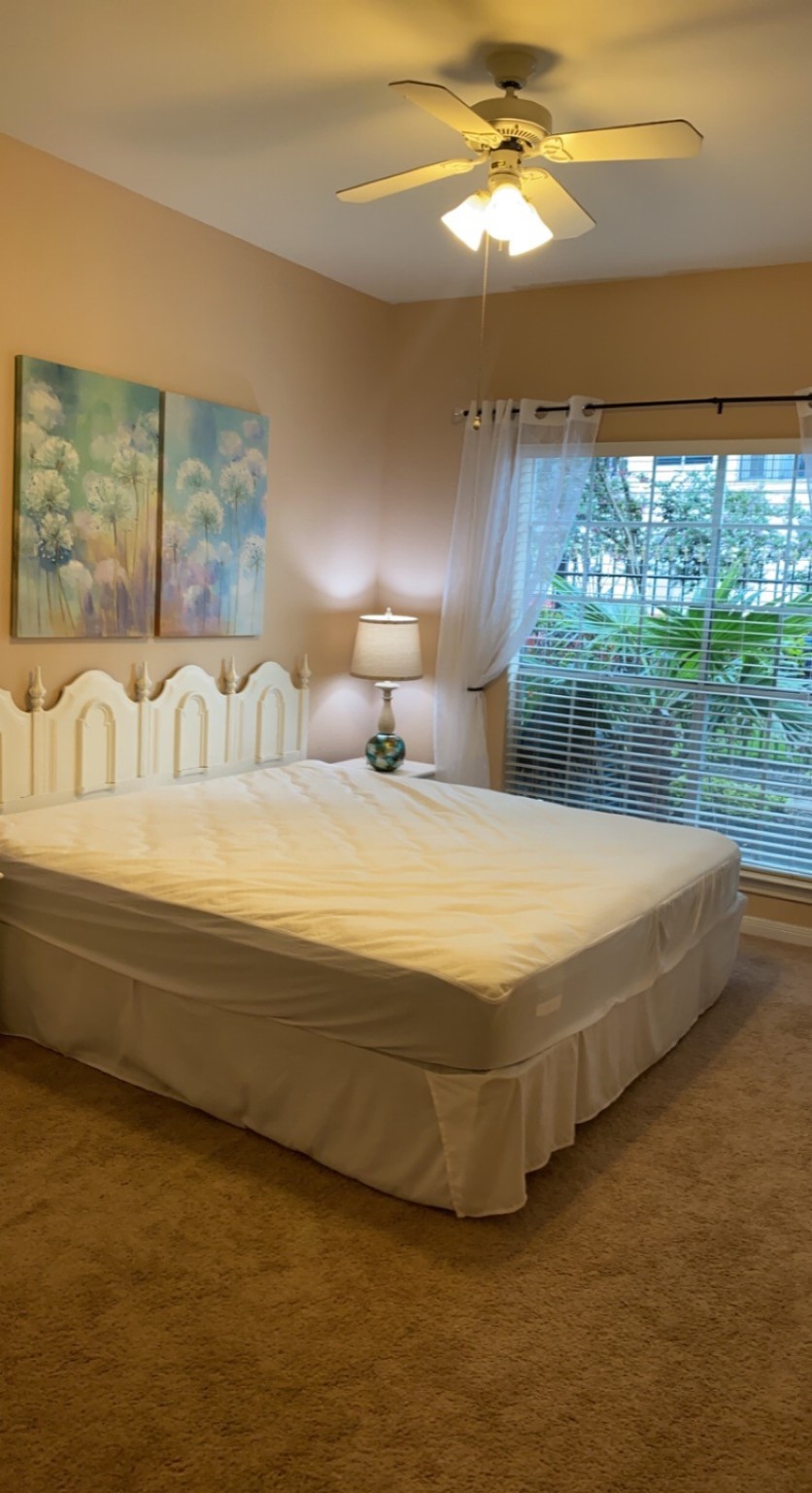 3231 Allen Parkway, Unit 2107 Houston, TX 77019 - Photo 20 of 48 a spacious bedroom with a bed and a chandelier