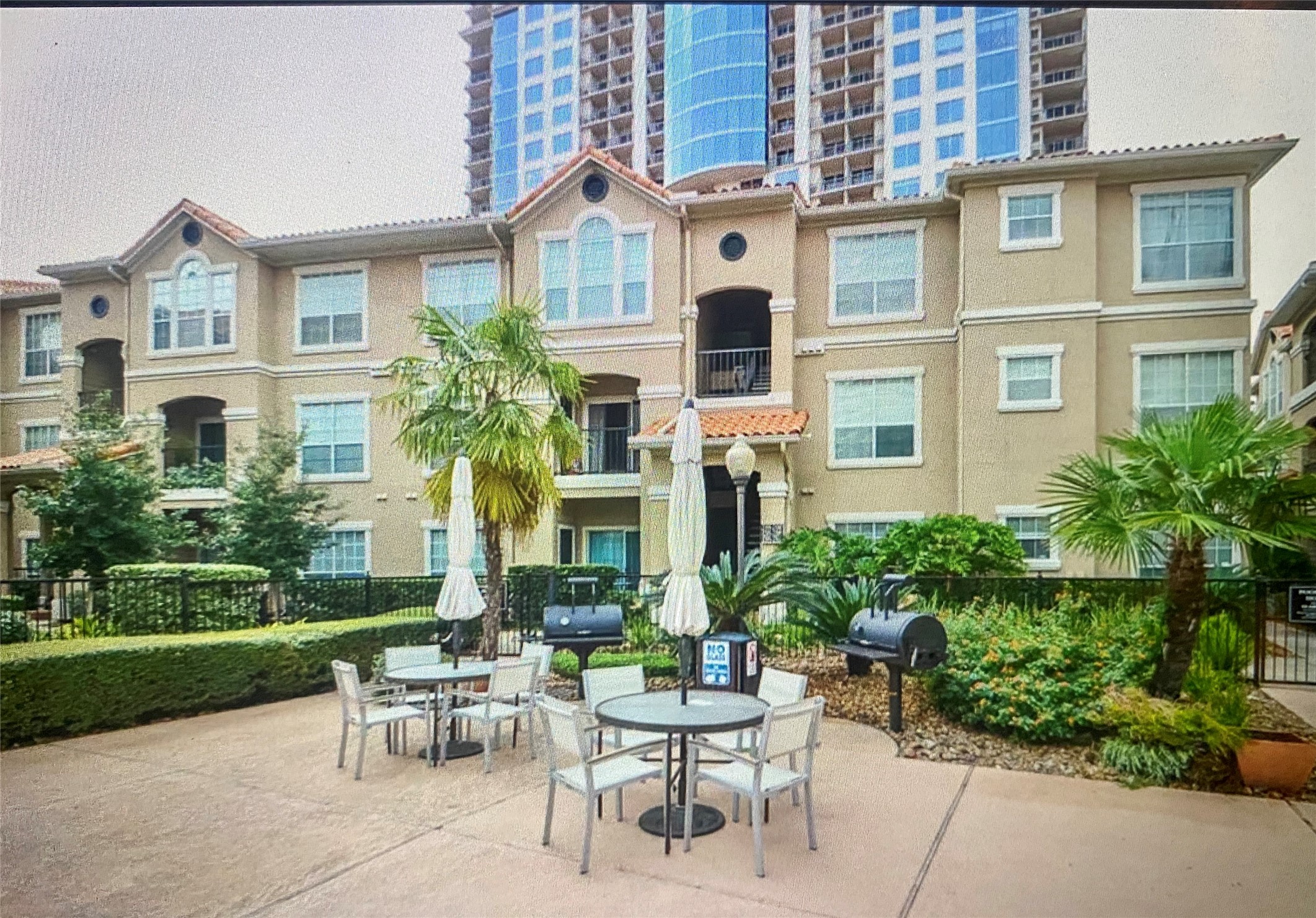 3231 Allen Parkway, Unit 2107 Houston, TX 77019 - Photo 3 of 48 a view of a brick building with a bench and table in front of a house