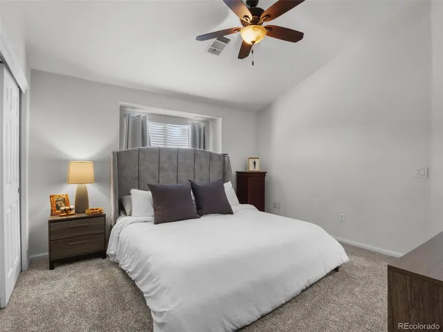 a bathroom with a granite countertop sink a toilet a mirror and shower