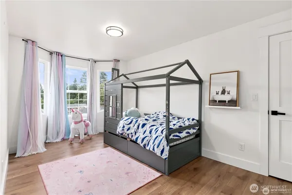 a bedroom with a bed next to a large window with the outer view