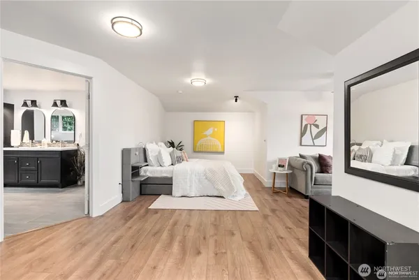 a spacious bedroom with a bed and wooden floor