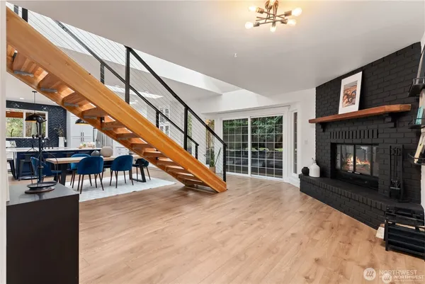 a view of an empty room with wooden floor a fireplace and windows
