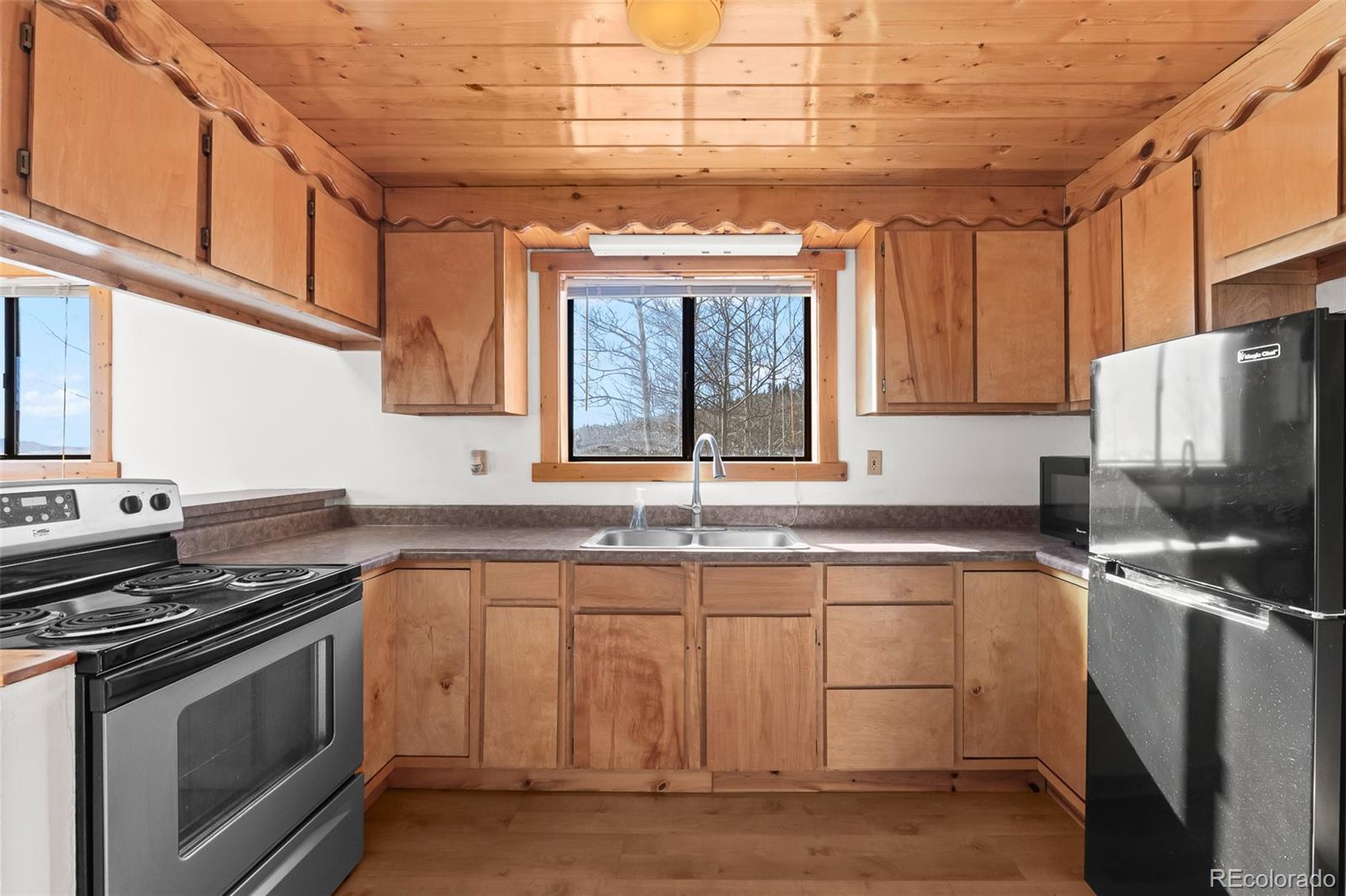 1793 Michigan Hill Road Jefferson, CO 80456 - Photo 16 of 44 a kitchen with granite countertop a sink stove and cabinets