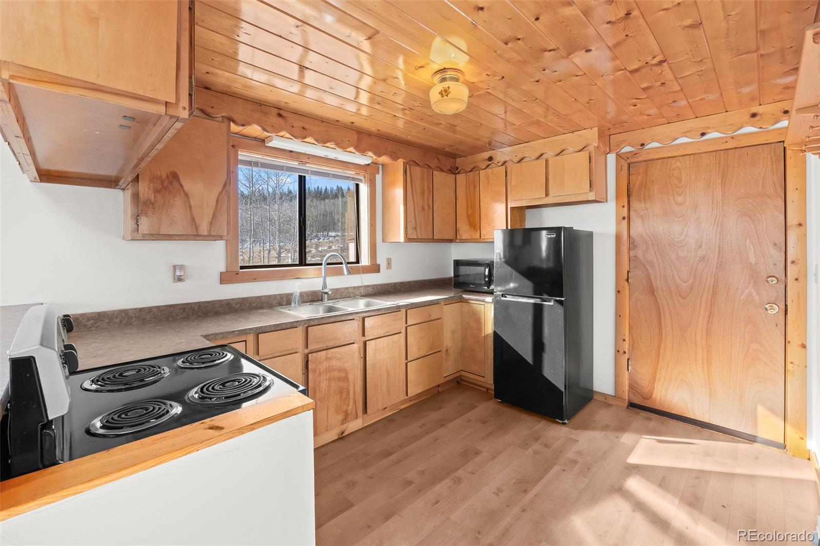 1793 Michigan Hill Road Jefferson, CO 80456 - Photo 17 of 44 a kitchen with a stove a sink and a refrigerator