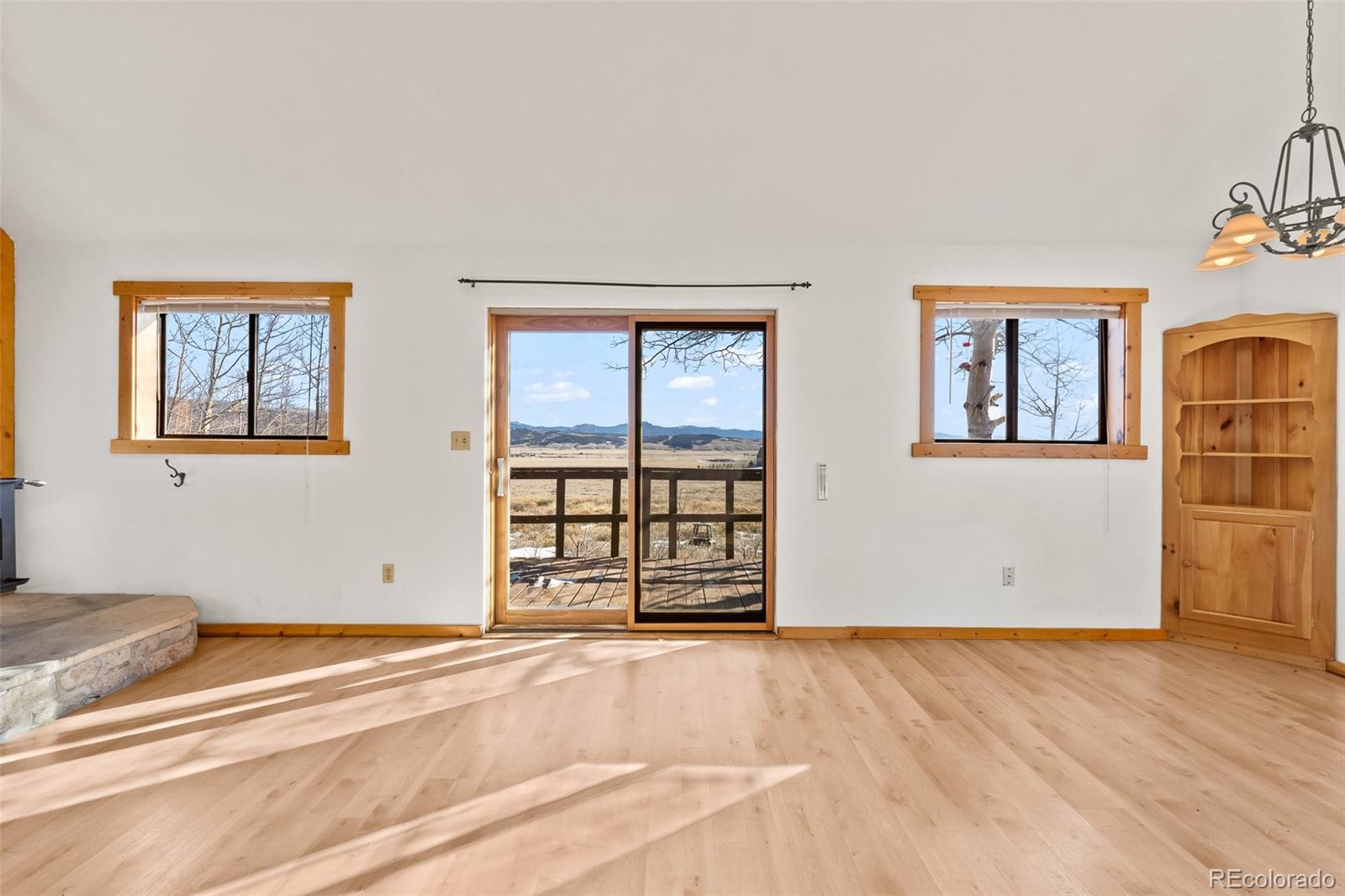 1793 Michigan Hill Road Jefferson, CO 80456 - Photo 19 of 44 a view of an empty room with wooden floor and windows