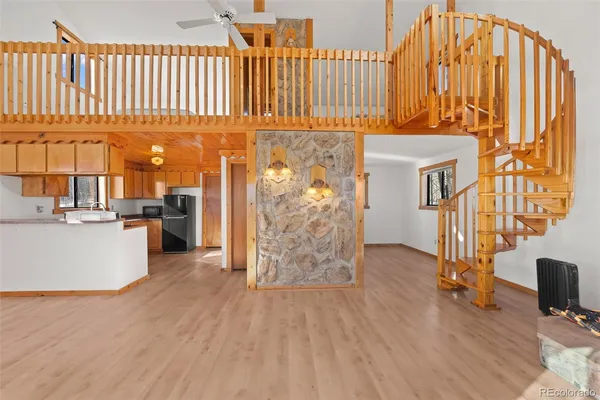 a view of a kitchen with furniture and wooden floor