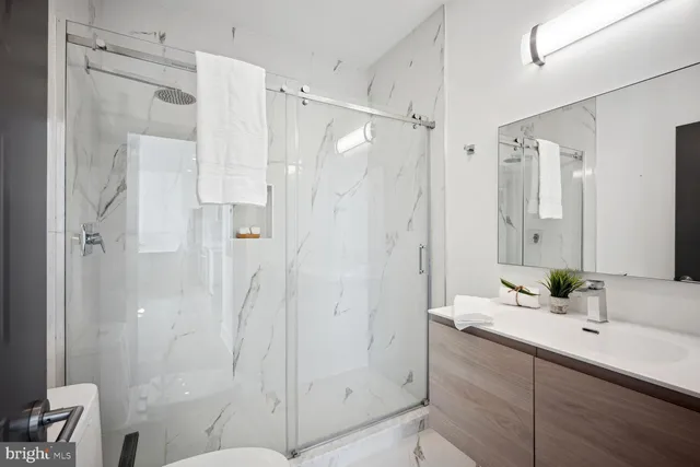 a bathroom with a shower sink and mirror