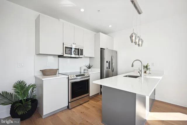 a kitchen with stainless steel appliances granite countertop a sink a stove and a refrigerator