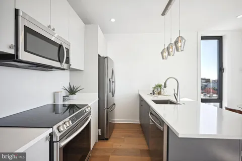 a kitchen with stainless steel appliances granite countertop a sink and a microwave