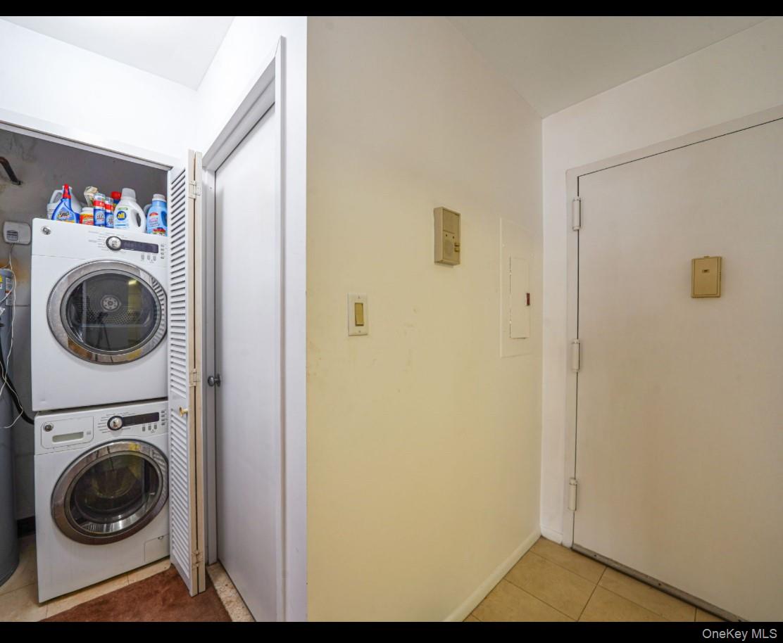 360 Shore Road, Unit 4B Long Beach, NY 11561 - Photo 26 of 28 Laundry room with stacked washer / dryer, light tile patterned floors, and electric panel